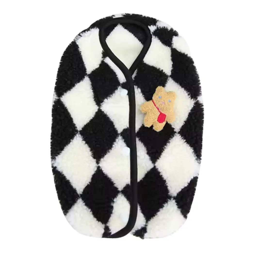 Chaleco Teddy color negro sobre superficie blanca, mostrando la tela suave